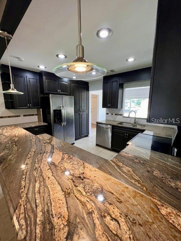 kitchen with sink, light tile patterned floors, pendant lighting, and appliances with stainless steel finishes