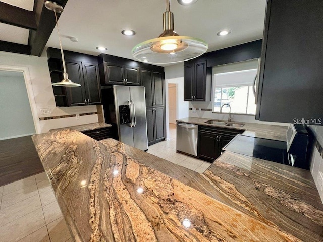 kitchen featuring light stone counters, sink, light tile patterned flooring, and stainless steel appliances