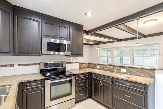 kitchen featuring light stone countertops, backsplash, dark brown cabinets, stainless steel appliances, and light tile patterned floors