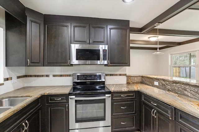 kitchen featuring tasteful backsplash, dark brown cabinetry, light stone counters, and appliances with stainless steel finishes