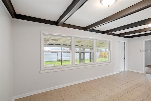 tiled empty room featuring beamed ceiling