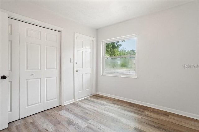 unfurnished bedroom with light hardwood / wood-style flooring and a closet