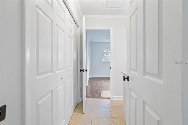 corridor featuring light tile patterned flooring and crown molding