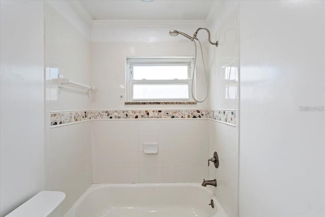 bathroom featuring ornamental molding, tiled shower / bath combo, and toilet