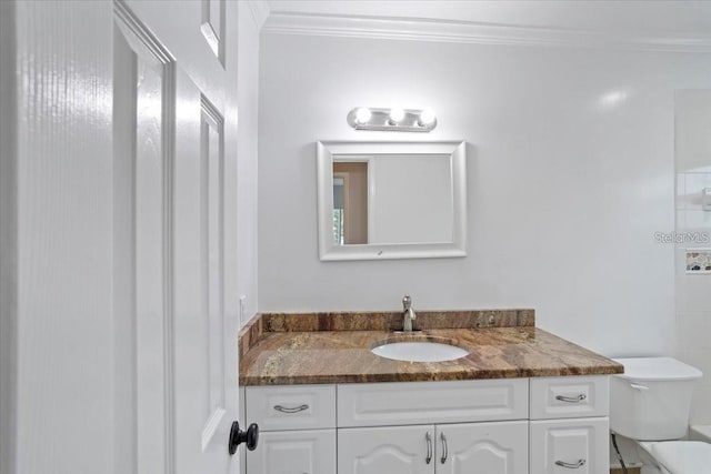 bathroom featuring vanity, toilet, and ornamental molding