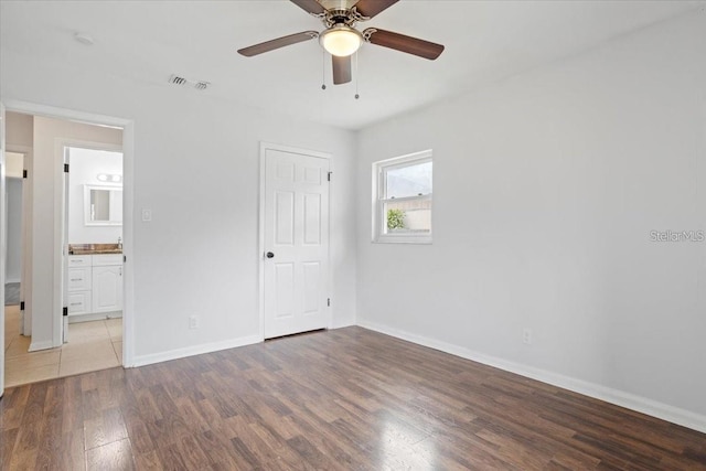 unfurnished bedroom featuring hardwood / wood-style flooring, ceiling fan, and ensuite bathroom