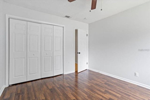 unfurnished bedroom with ceiling fan, dark hardwood / wood-style flooring, and a closet