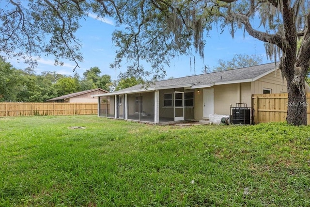 back of house with a sunroom, a yard, and central AC unit