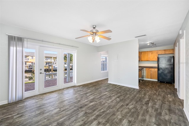 unfurnished living room featuring ceiling fan and dark hardwood / wood-style flooring