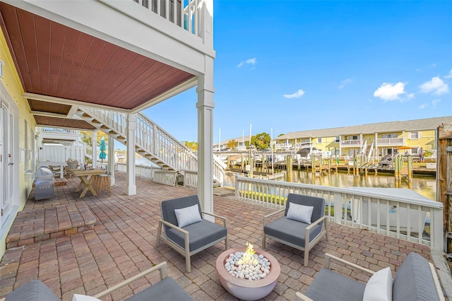 view of patio featuring a dock, a water view, and a fire pit