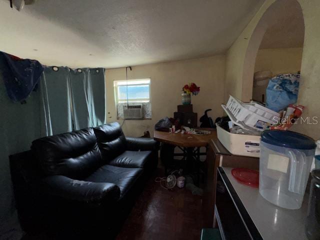 living room with cooling unit, wood-type flooring, and a textured ceiling