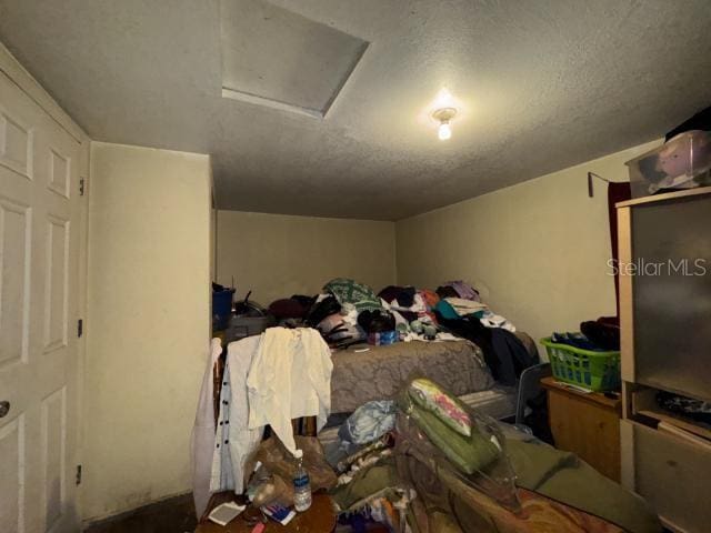 bedroom featuring lofted ceiling and a textured ceiling