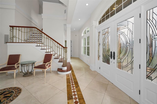 entrance foyer featuring crown molding, french doors, and light tile patterned flooring