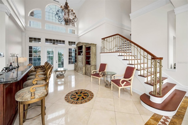 119 8th St E, Tierra Verde, FL 33715 - tiled foyer entrance with stairs, french doors, a high ceiling, and a chandelier