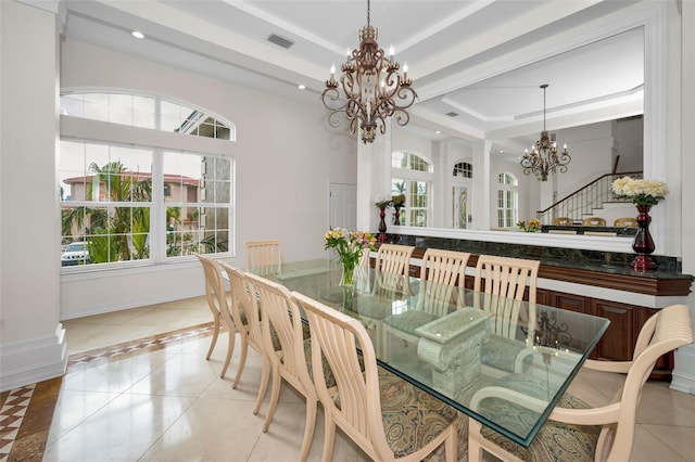 tiled dining area featuring a raised ceiling and a chandelier