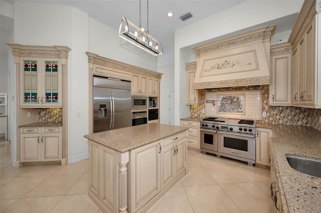 119 8th St E, Tierra Verde, FL 33715 - kitchen with cream cabinetry, built in appliances, decorative backsplash, light tile patterned floors, and recessed lighting