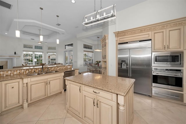 kitchen with built in appliances, a center island, sink, and pendant lighting