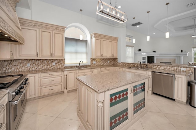 119 8th St E, Tierra Verde, FL 33715 - kitchen featuring cream cabinets, stainless steel appliances, custom exhaust hood, open floor plan, and tasteful backsplash