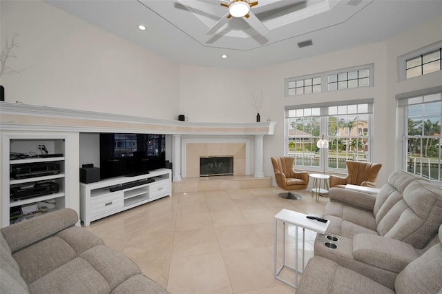 tiled living room featuring ceiling fan, built in features, and a fireplace