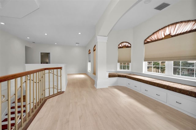 119 8th St E, Tierra Verde, FL 33715 - hallway featuring light wood-type flooring, recessed lighting, arched walkways, and an upstairs landing