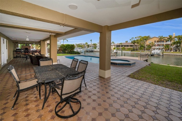 view of patio / terrace featuring a swimming pool with hot tub, a water view, and ceiling fan