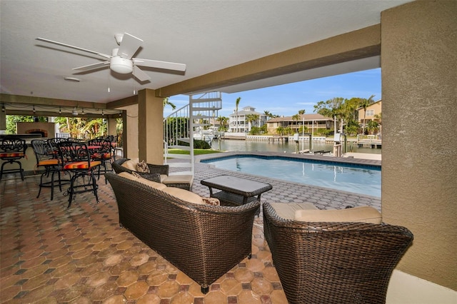 view of pool featuring a water view, ceiling fan, and a patio area