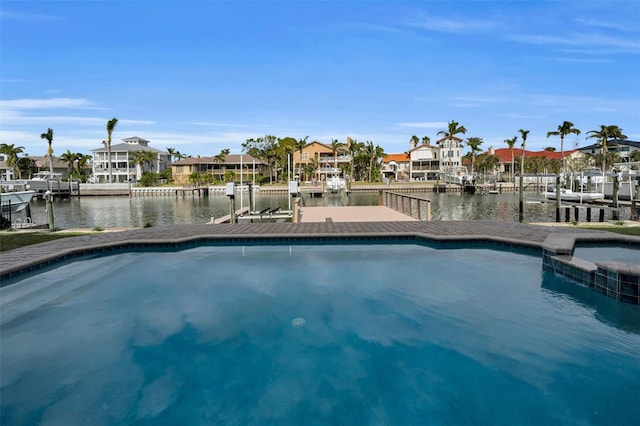 view of swimming pool with a boat dock and a water view