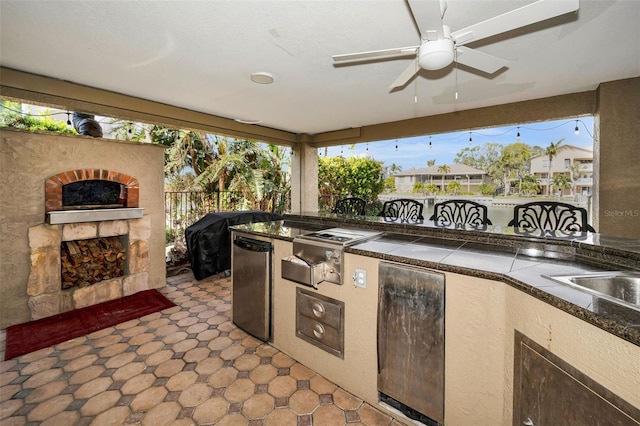 view of patio featuring ceiling fan, area for grilling, and a fireplace