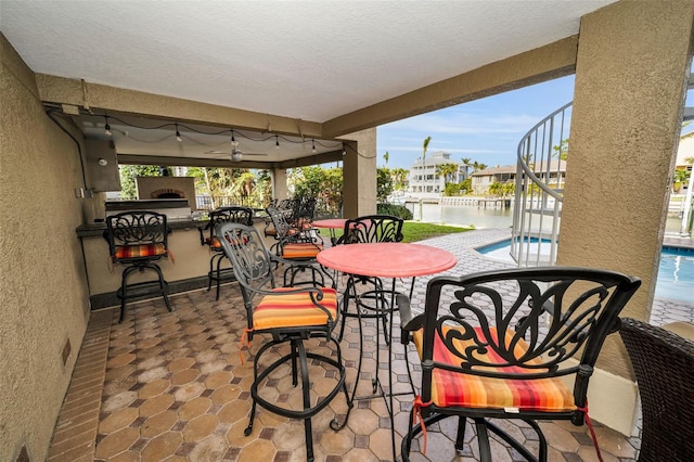 119 8th St E, Tierra Verde, FL 33715 - view of patio / terrace with an outdoor pool and a water view