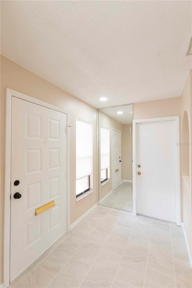 tiled foyer with a textured ceiling