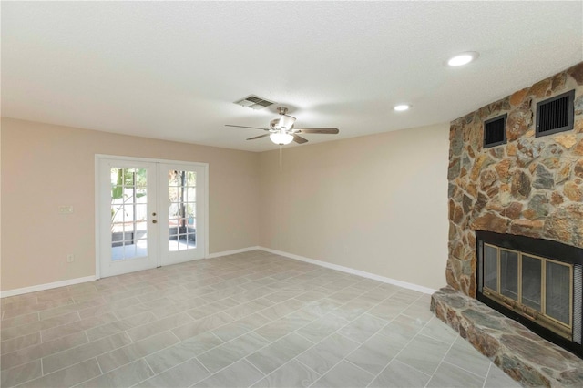 living room featuring a fireplace, french doors, a textured ceiling, and ceiling fan