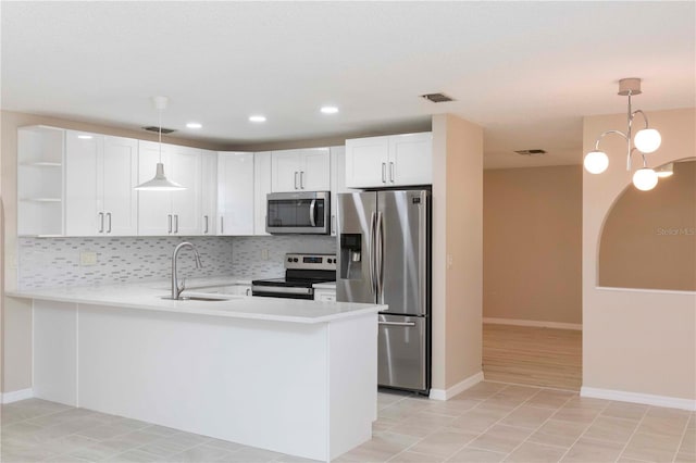 kitchen featuring sink, hanging light fixtures, white cabinetry, kitchen peninsula, and stainless steel appliances