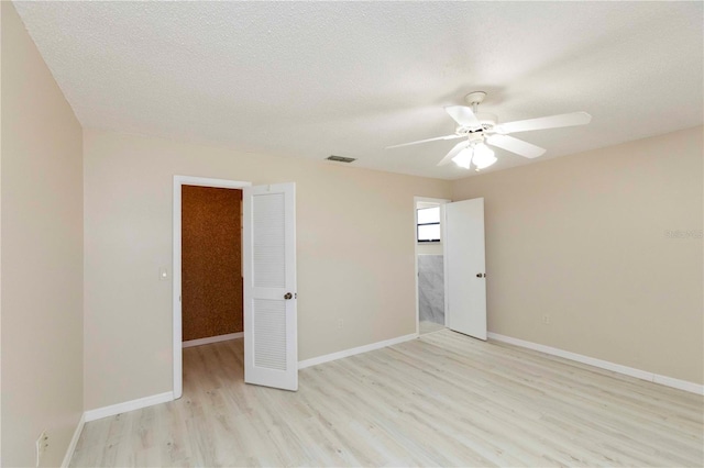 spare room featuring ceiling fan, light hardwood / wood-style floors, and a textured ceiling