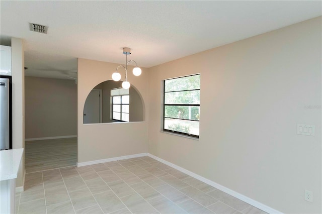 spare room with a chandelier