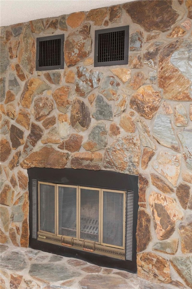 interior details featuring a stone fireplace