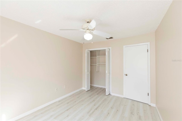 unfurnished bedroom featuring ceiling fan, light wood-type flooring, and a textured ceiling