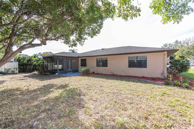 rear view of property featuring a yard and a sunroom