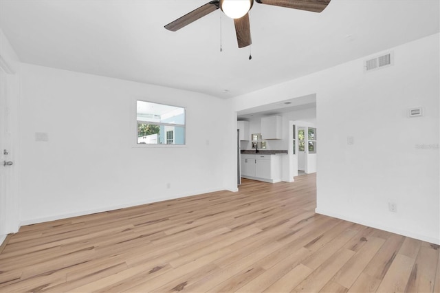 unfurnished living room with ceiling fan and light hardwood / wood-style flooring