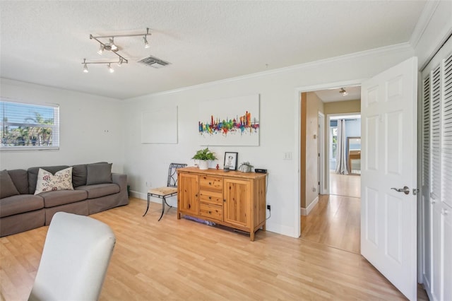 living room with a textured ceiling, hardwood / wood-style flooring, and crown molding