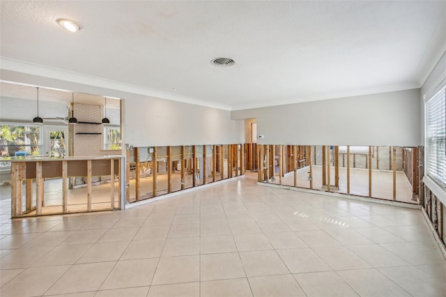 empty room with ornamental molding and light tile patterned floors