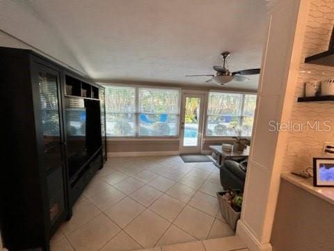 tiled living room featuring ceiling fan