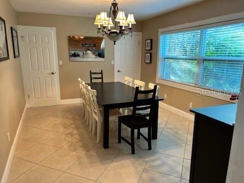 tiled dining space with a chandelier