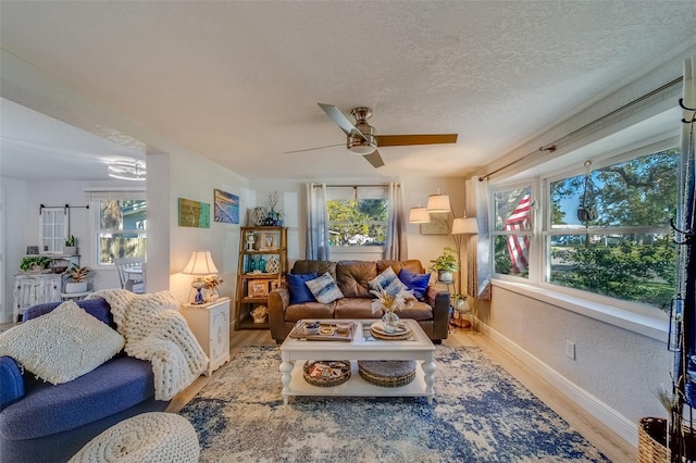 living room featuring plenty of natural light, wood-type flooring, and a textured ceiling