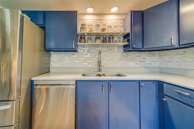 kitchen with blue cabinets, sink, a textured ceiling, appliances with stainless steel finishes, and tasteful backsplash