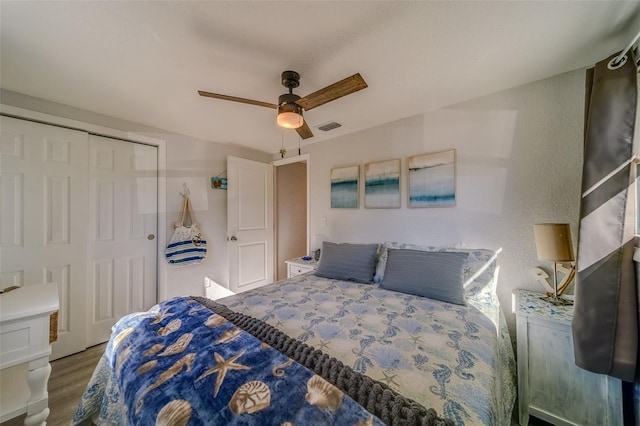 bedroom with ceiling fan, a closet, and dark wood-type flooring