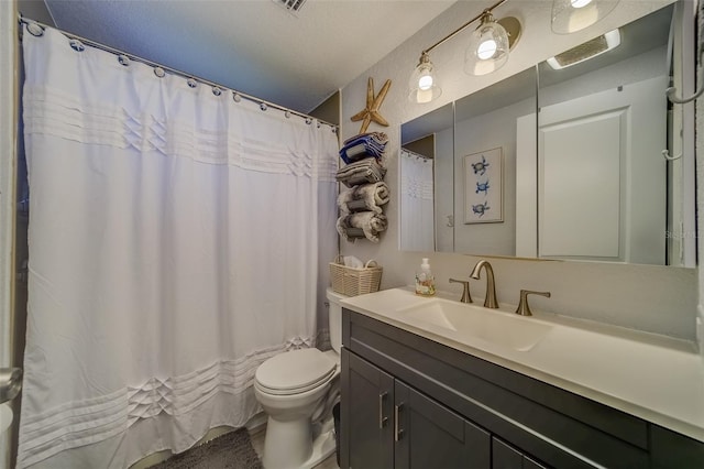 bathroom with vanity, toilet, and a textured ceiling