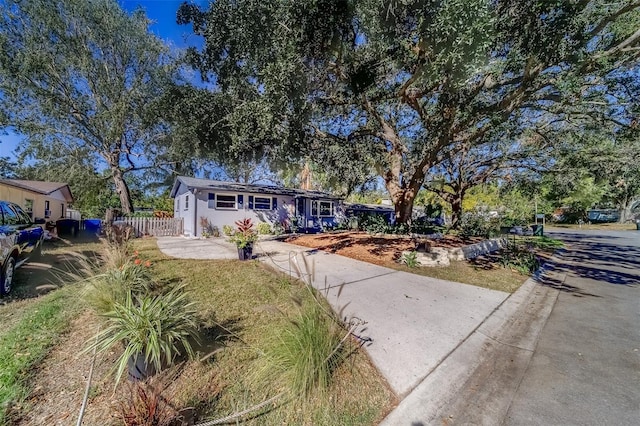 view of front facade with a front lawn and solar panels