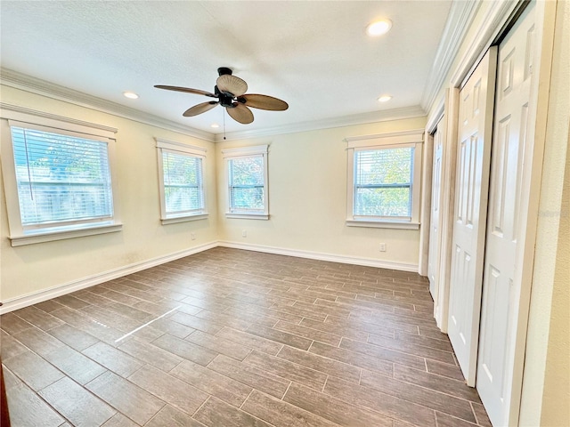 unfurnished bedroom with dark hardwood / wood-style flooring, two closets, ceiling fan, and ornamental molding