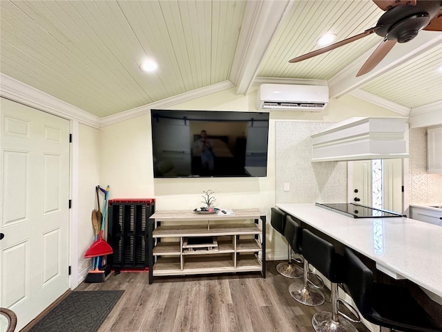 living room featuring crown molding, vaulted ceiling, hardwood / wood-style flooring, ceiling fan, and a wall unit AC