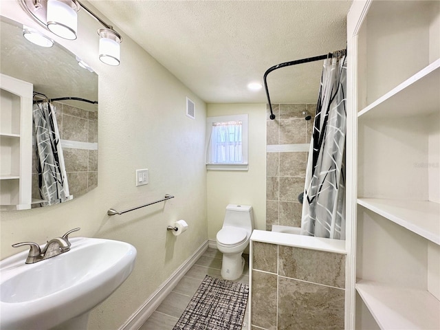 full bathroom with a textured ceiling, shower / bath combo with shower curtain, sink, tile patterned flooring, and toilet